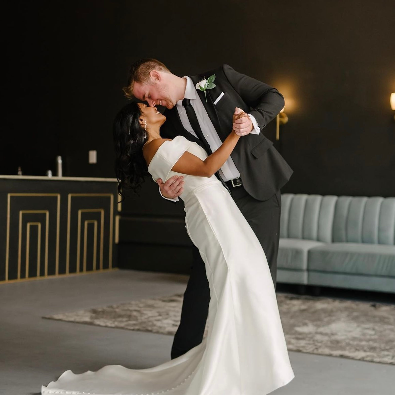 A couple dancing in the black-walled lounge, genuine gold Art Deco molding on the bar front and velvet seating behind them.