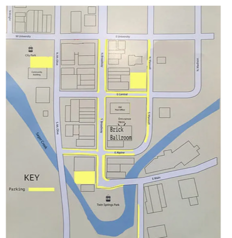 Map of downtown Siloam Springs with the Brick Ballroom marked at the centre and the nearby public parking lots shaded in yellow, all within one block.