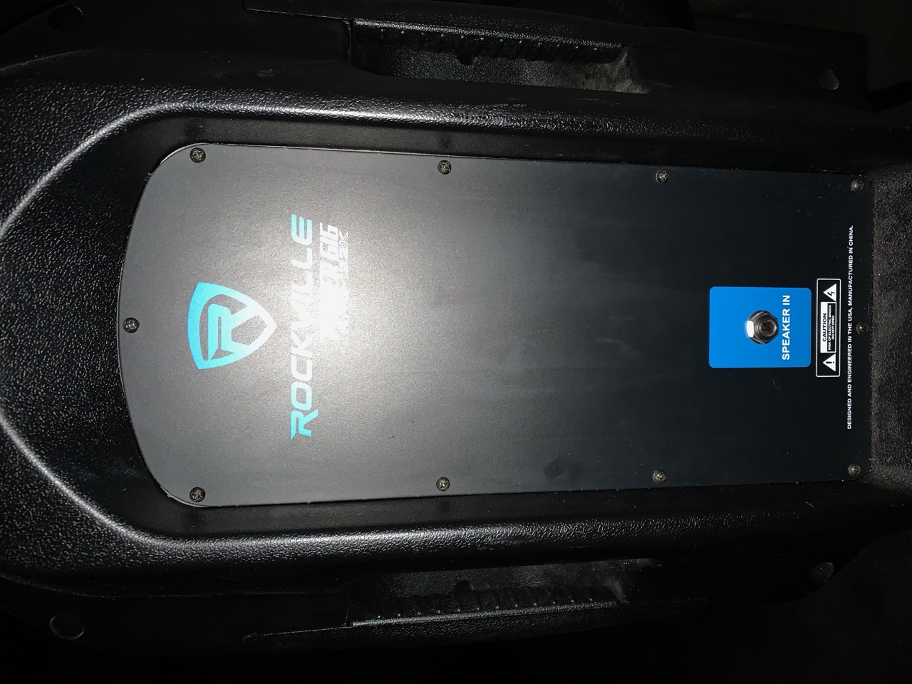 One of the two Rockville powered speakers, seen head-on with its control panel lit.