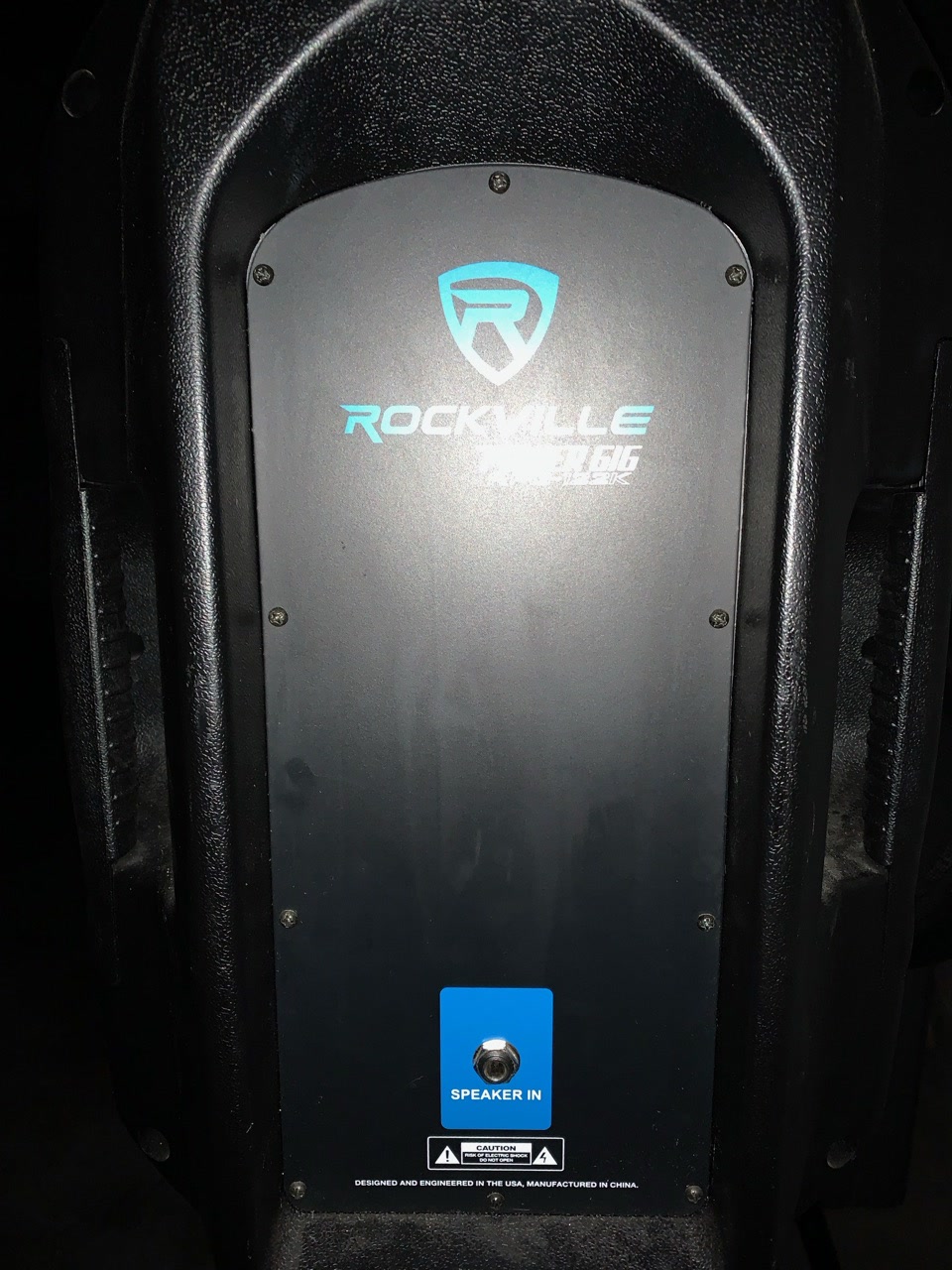 One of the two Rockville powered speakers, seen head-on with its control panel lit.
